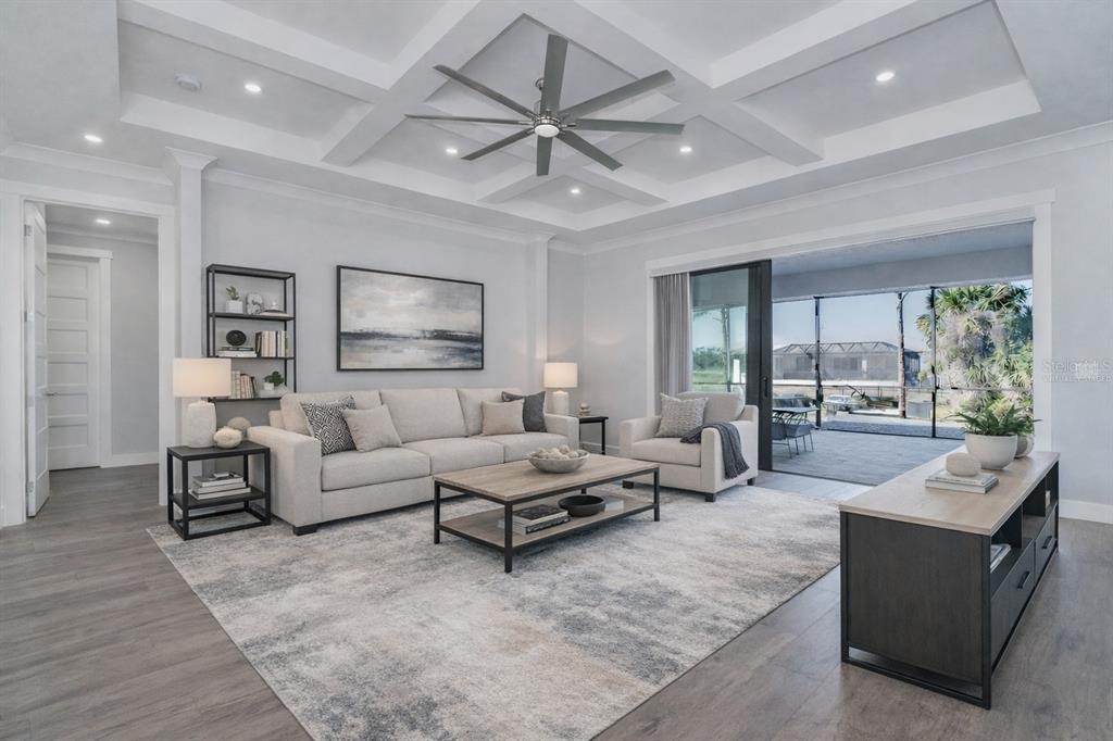 A bright living room features a coffered ceiling, a ceiling fan, and sliding glass patio doors — 237 W PINE VALLEY LANE, ROTONDA WEST, FL
