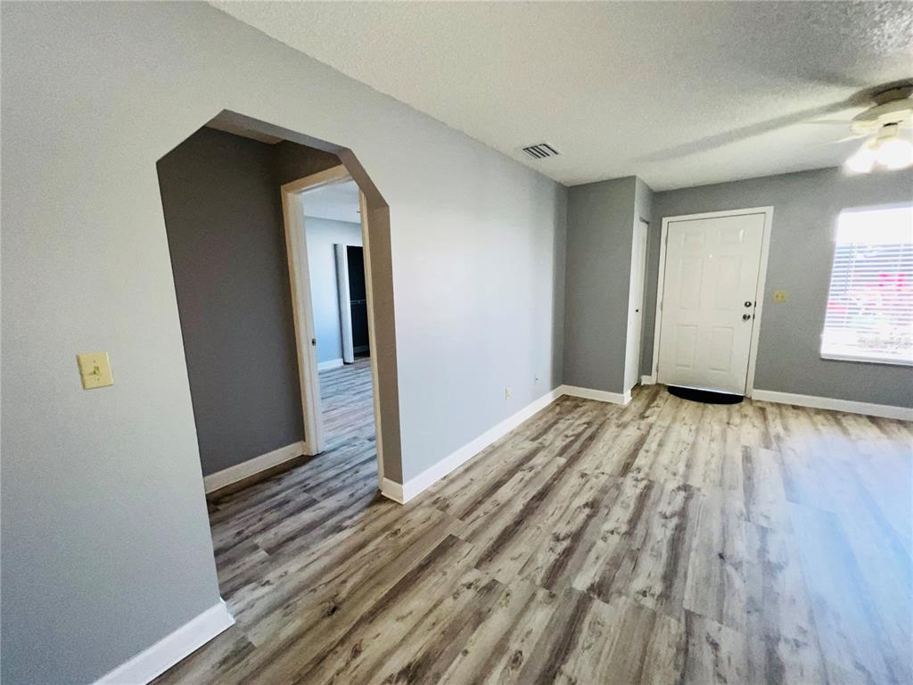 An interior room features light gray walls, wood-look flooring, and an arched doorway — 605 RIDGE TERRACE UNIT 605, WINTER HAVEN, FL