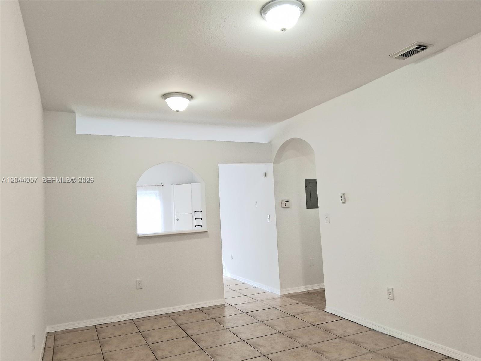 An interior room features white walls, tiled flooring, two ceiling lights, and an arched cutout — 6972 NW 179th St # 4, Hialeah FL 33015, HIALEAH, FL