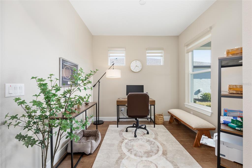 A home office features a desk, chair, area rug, bench, and a tall plant — 8919 SW 58TH STREET ROAD, OCALA, FL