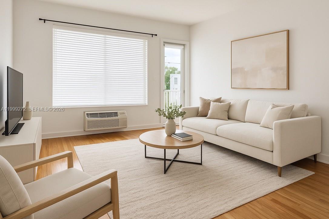 This living room features a beige sofa, a round coffee table, and hardwood flooring — 505 74th St # 6B, Miami Beach FL 33141, MIAMI BEACH, FL