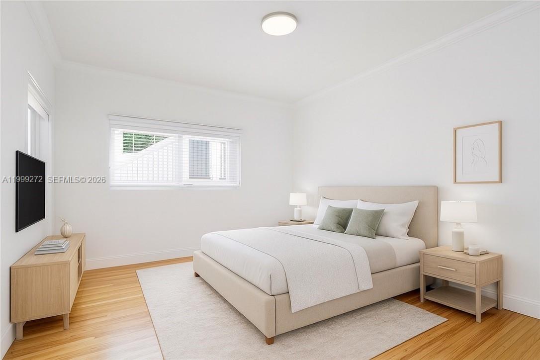 This bedroom features a bed, two nightstands, a media console, and light wood flooring — 505 74th St # 6B, Miami Beach FL 33141, MIAMI BEACH, FL