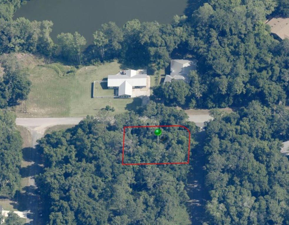 An aerial view shows a wooded, rectangular plot of land outlined in red near a lake — 11704 N LANDOVER TERRACE, CITRUS SPRINGS, FL