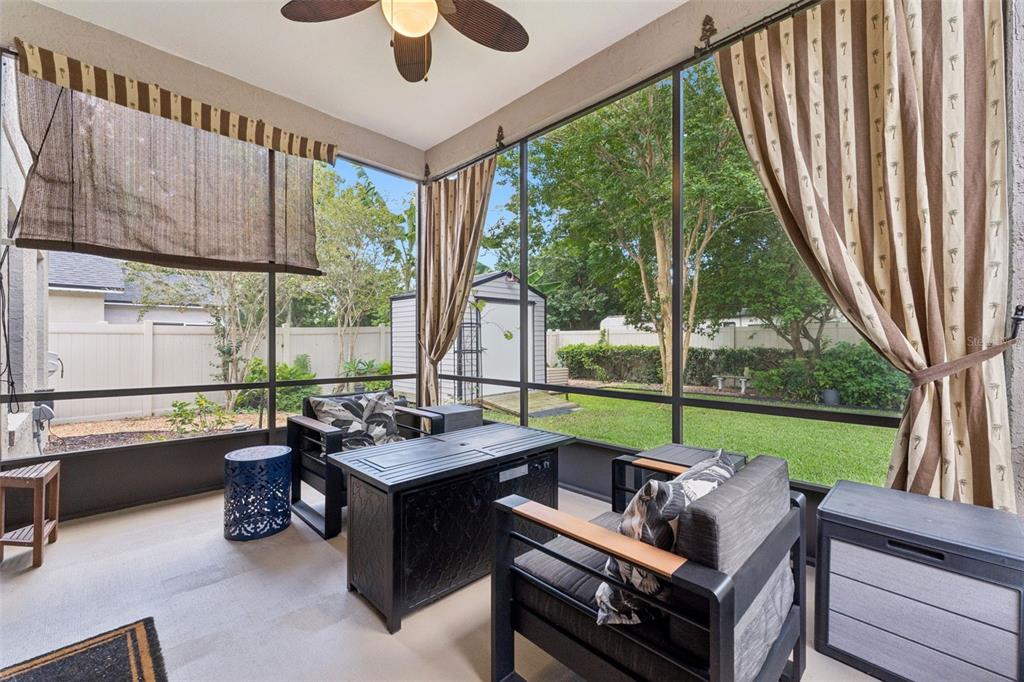 A screened-in patio features dark outdoor furniture, a ceiling fan, and views of a backyard — 293 KETTERING ROAD, DELTONA, FL