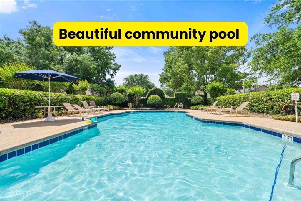An outdoor community swimming pool is surrounded by lounge chairs, a patio, and manicured hedges — 293 KETTERING ROAD, DELTONA, FL
