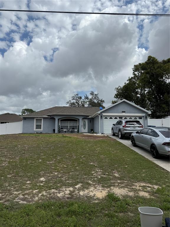 A single-story house with a gray exterior, a two-car garage, and a large front lawn — 11435 PICKFORD STREET, SPRING HILL, FL