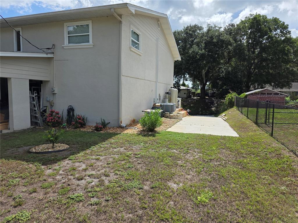 The exterior of a two-story house features a concrete patio and a fenced backyard — 14365 SE 107TH AVENUE, SUMMERFIELD, FL