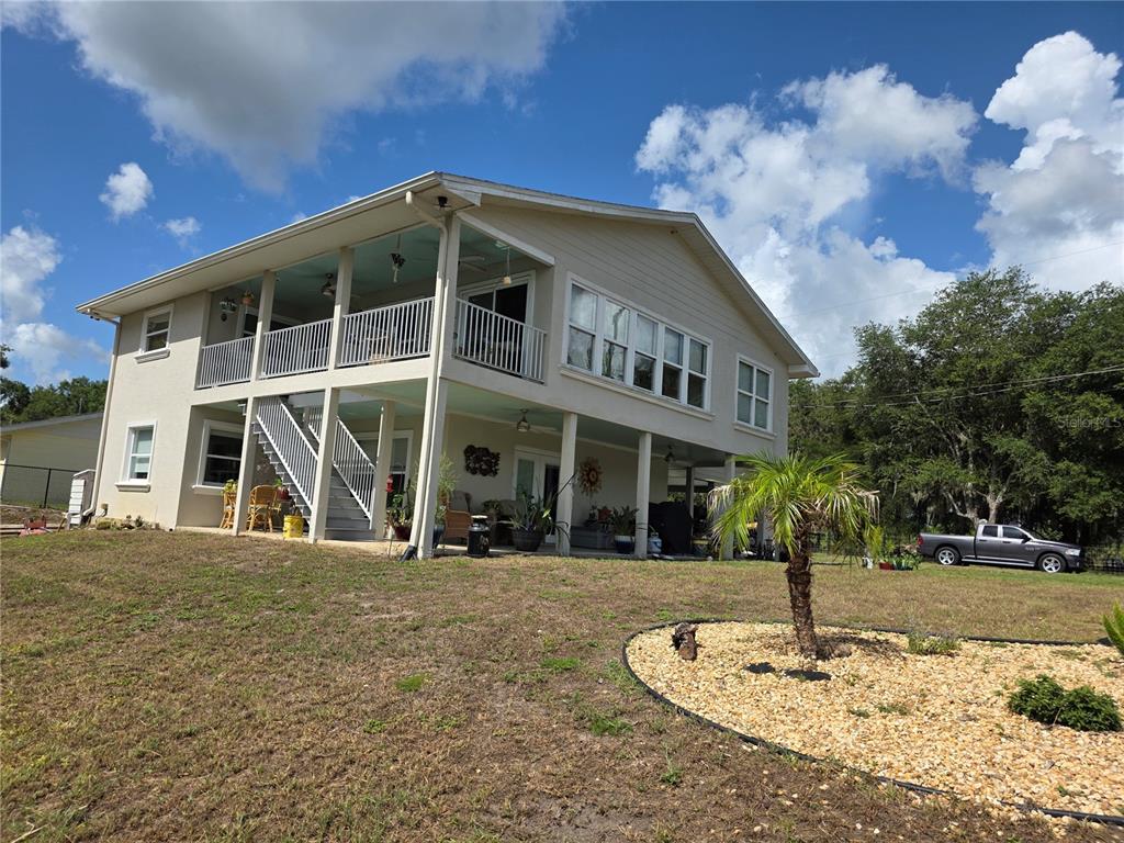 A two-story house with a wrap-around porch, balcony, and a gravel landscaping bed — 14365 SE 107TH AVENUE, SUMMERFIELD, FL