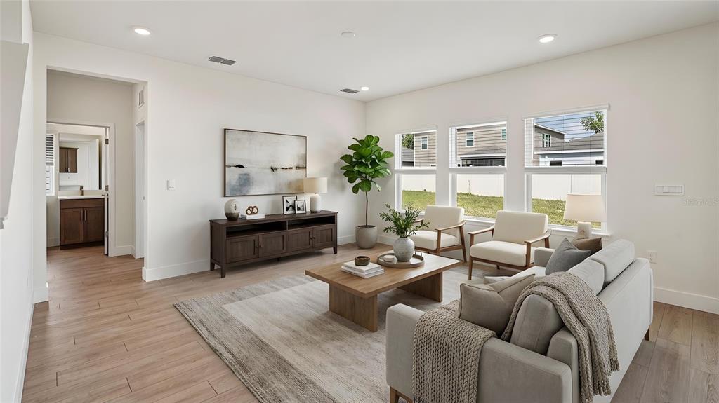 A living room features light wood floors, a beige sofa, two armchairs, and large windows — 11225 DUCKLING WAY, WEEKI WACHEE, FL