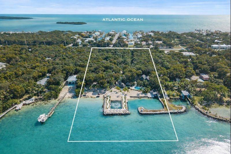 An aerial view shows a waterfront property with a private dock and sandy beach area — 95410 Overseas Highway, Key Largo FL 33037, KEY LARGO, FL