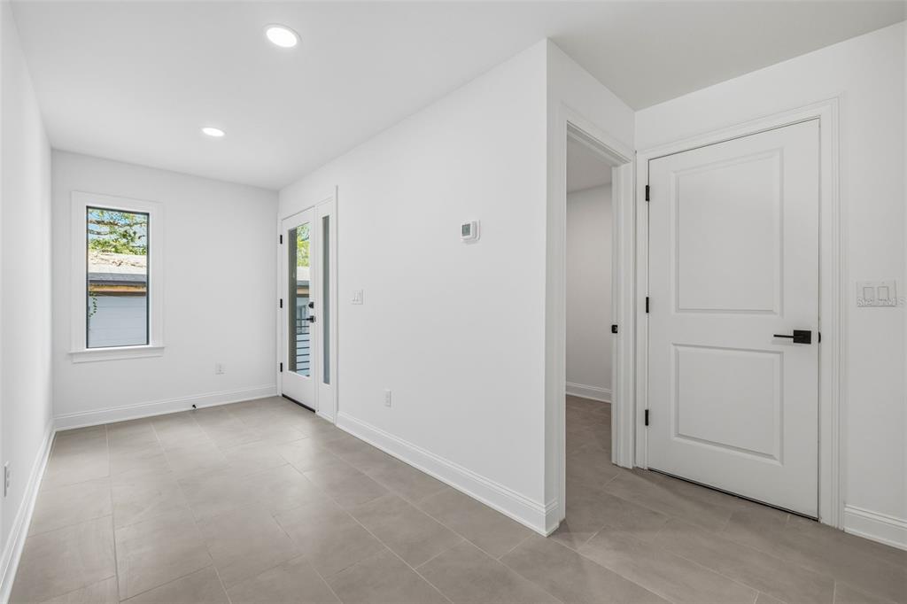 A bright entryway features light gray tile flooring, white walls, a glass-paneled door, and recessed lighting — 4509 W NORTH A STREET UNIT 1, TAMPA, FL