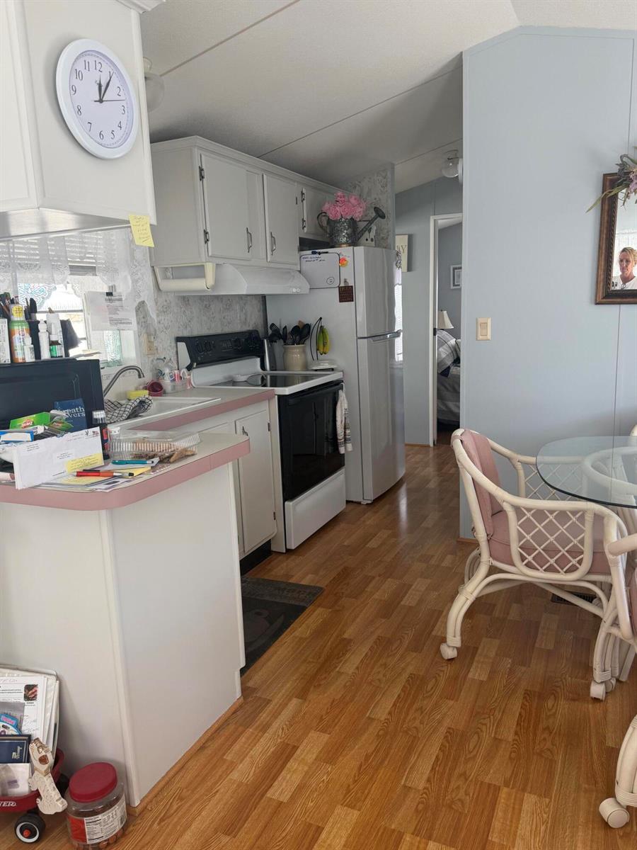 A kitchen features white cabinets, laminate countertops, a white stove, and light wood-look flooring — 1361 Overseas Highway # G15, Marathon FL 33050, MARATHON, FL