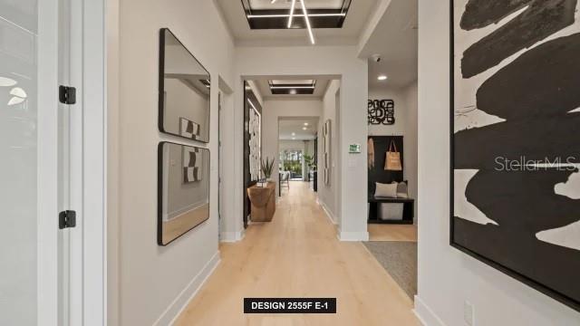 A bright hallway features light wood flooring, two stacked mirrors, and a large abstract painting — 13032 CAMELOT LANE, PUNTA GORDA, FL