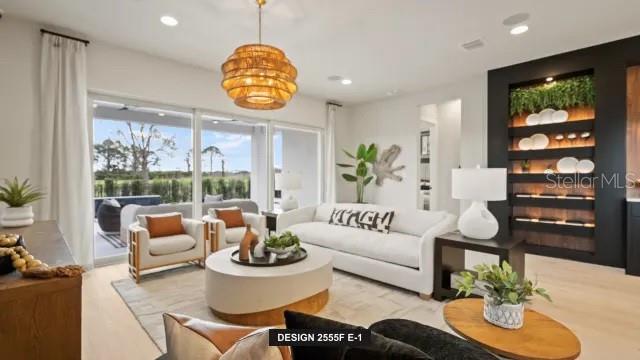 A bright living room features a white sofa, two armchairs, a round coffee table, and built-in shelving — 13032 CAMELOT LANE, PUNTA GORDA, FL