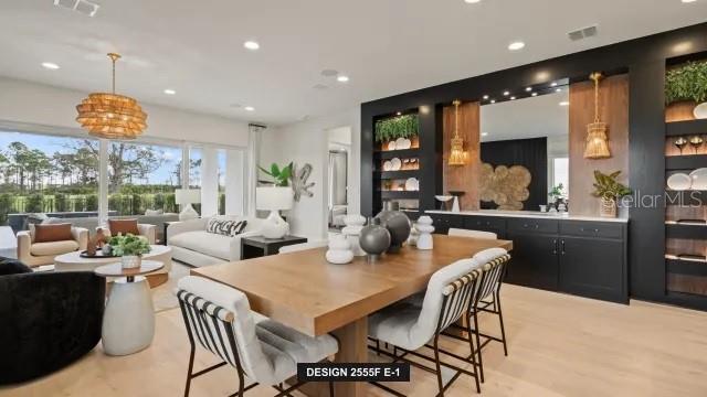 A modern dining room features a wooden table, black built-in shelving, and large glass windows — 13032 CAMELOT LANE, PUNTA GORDA, FL