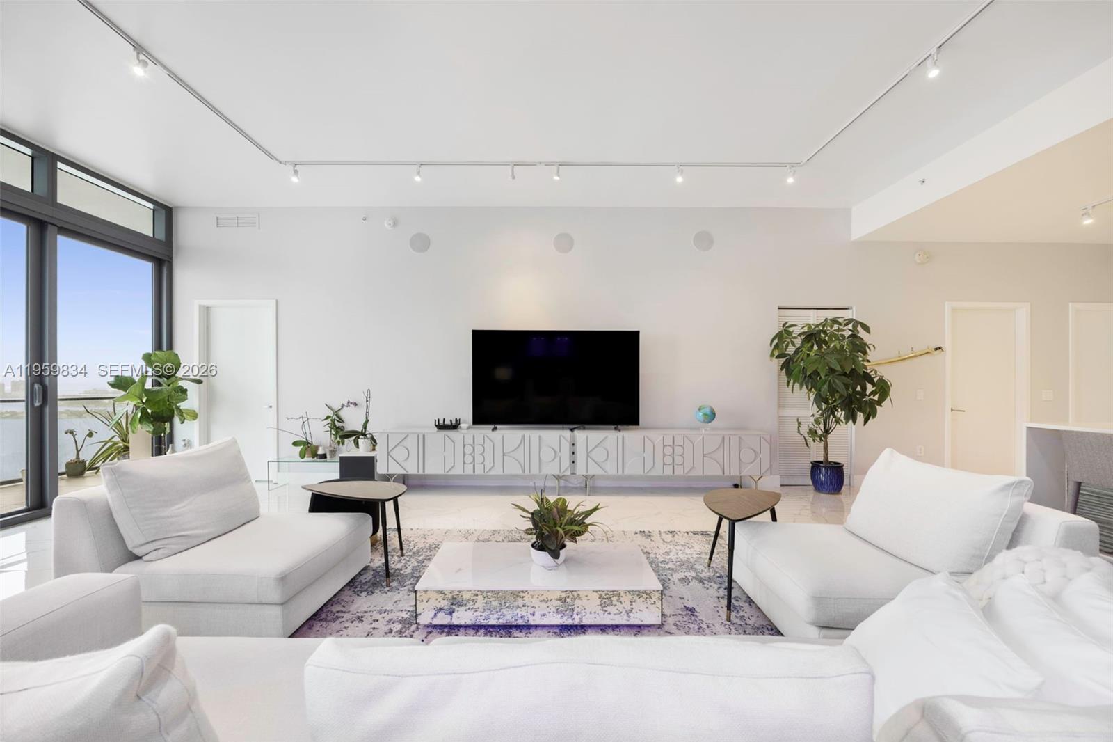 A bright living room features white sofas, a patterned area rug, and a media console — 460 NE 28th St # 4002, Miami FL 33137, MIAMI, FL