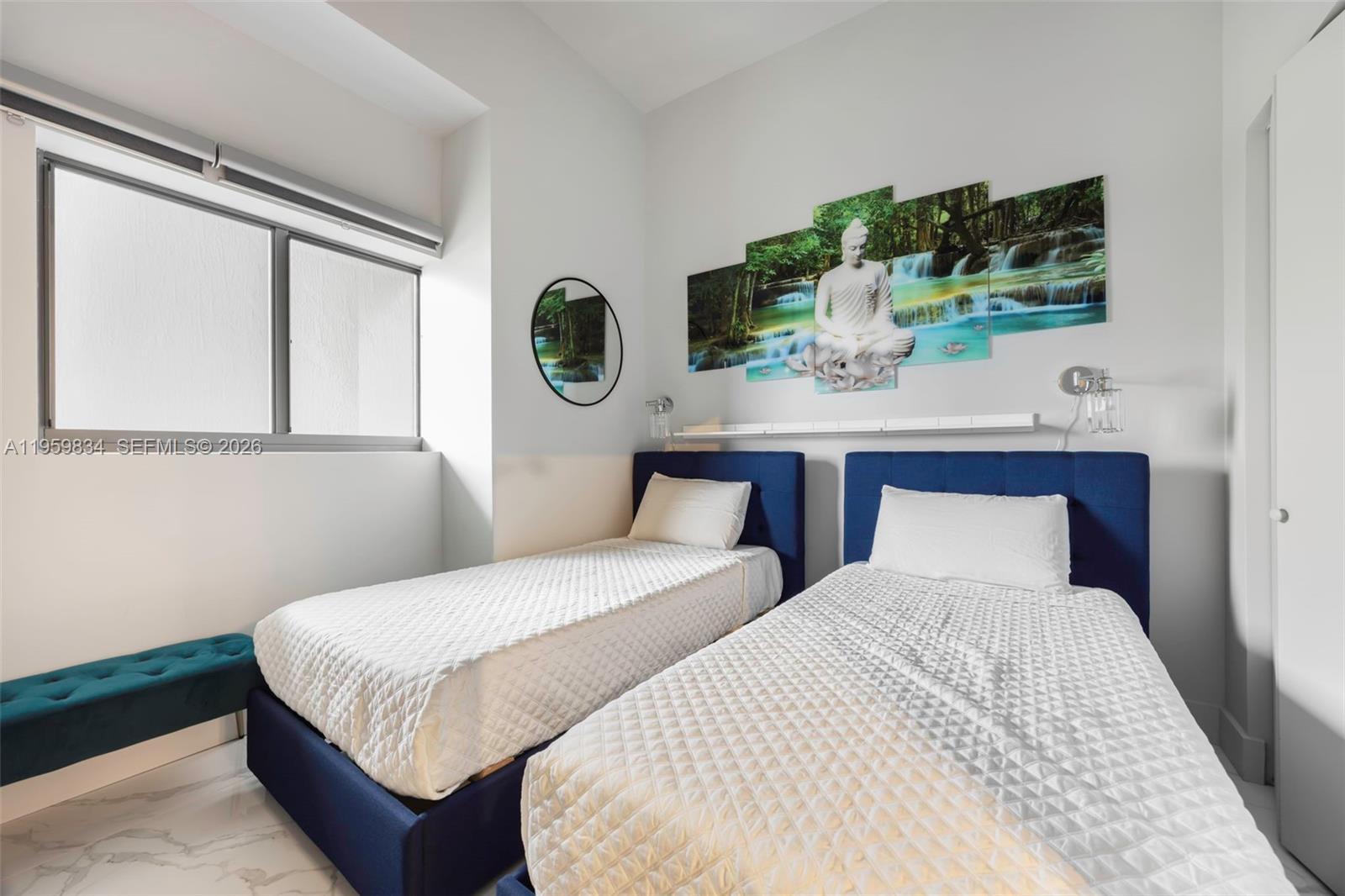 A bedroom features two twin beds with blue upholstered frames and a large Buddha wall mural — 460 NE 28th St # 4002, Miami FL 33137, MIAMI, FL