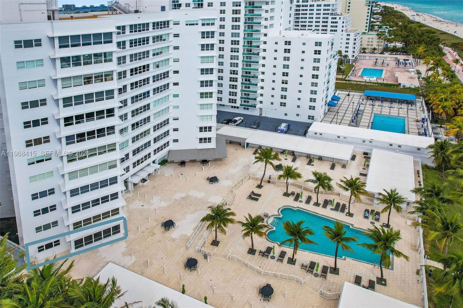 An aerial view of a white apartment building with a pool deck and palm trees — 4925 Collins Ave # 1A, Miami Beach FL 33140, MIAMI BEACH, FL