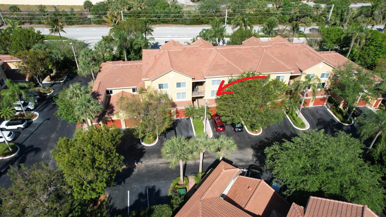 An aerial view of a multi-story residential building with a red tile roof and parking — 800 Scotia Drive # 203, Hypoluxo FL 33462, HYPOLUXO, FL
