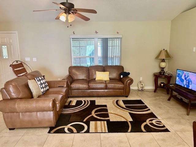 A living room features brown leather sofas, a patterned area rug, and a ceiling fan — 2551 SW HARBOR HILLS ROAD, DUNNELLON, FL