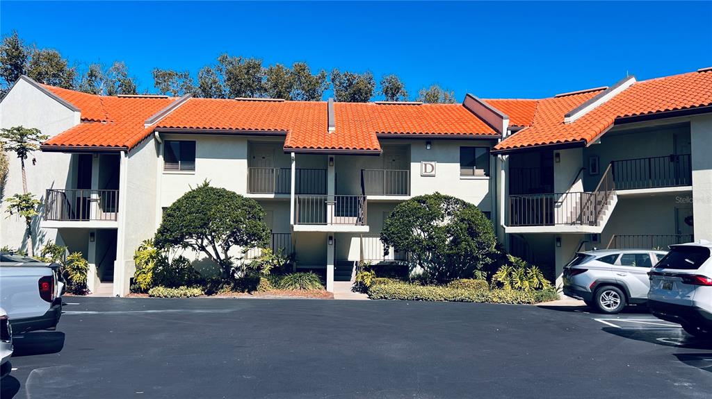A two-story apartment building with a red tile roof and a parking lot in front — 1515 PINELLAS BAYWAY S UNIT 46, ST PETERSBURG, FL