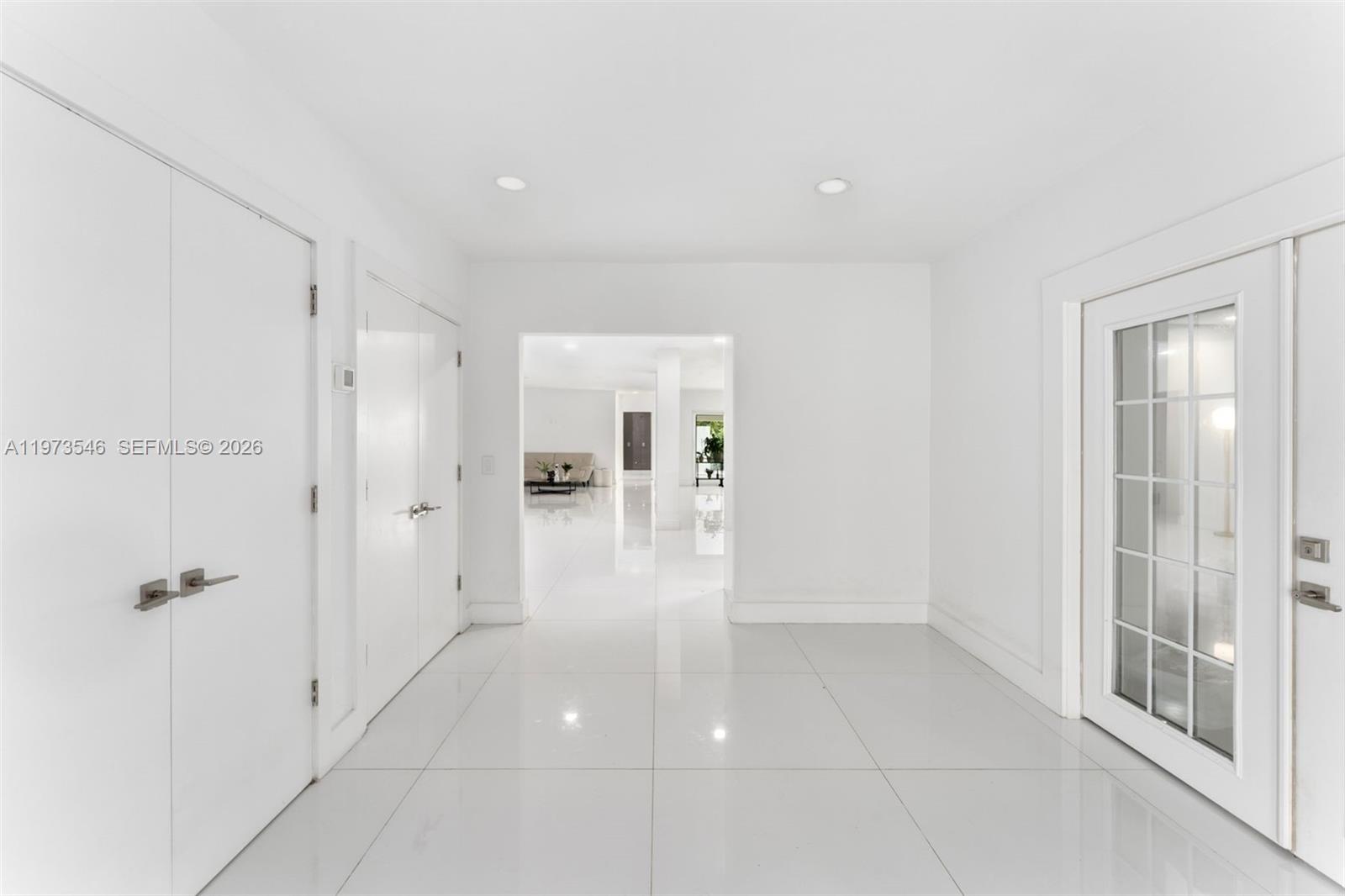 A bright, white-tiled entryway features double doors, a glass-paned door, and a central hallway opening — 400 SW 24th Rd, Miami FL 33129, MIAMI, FL