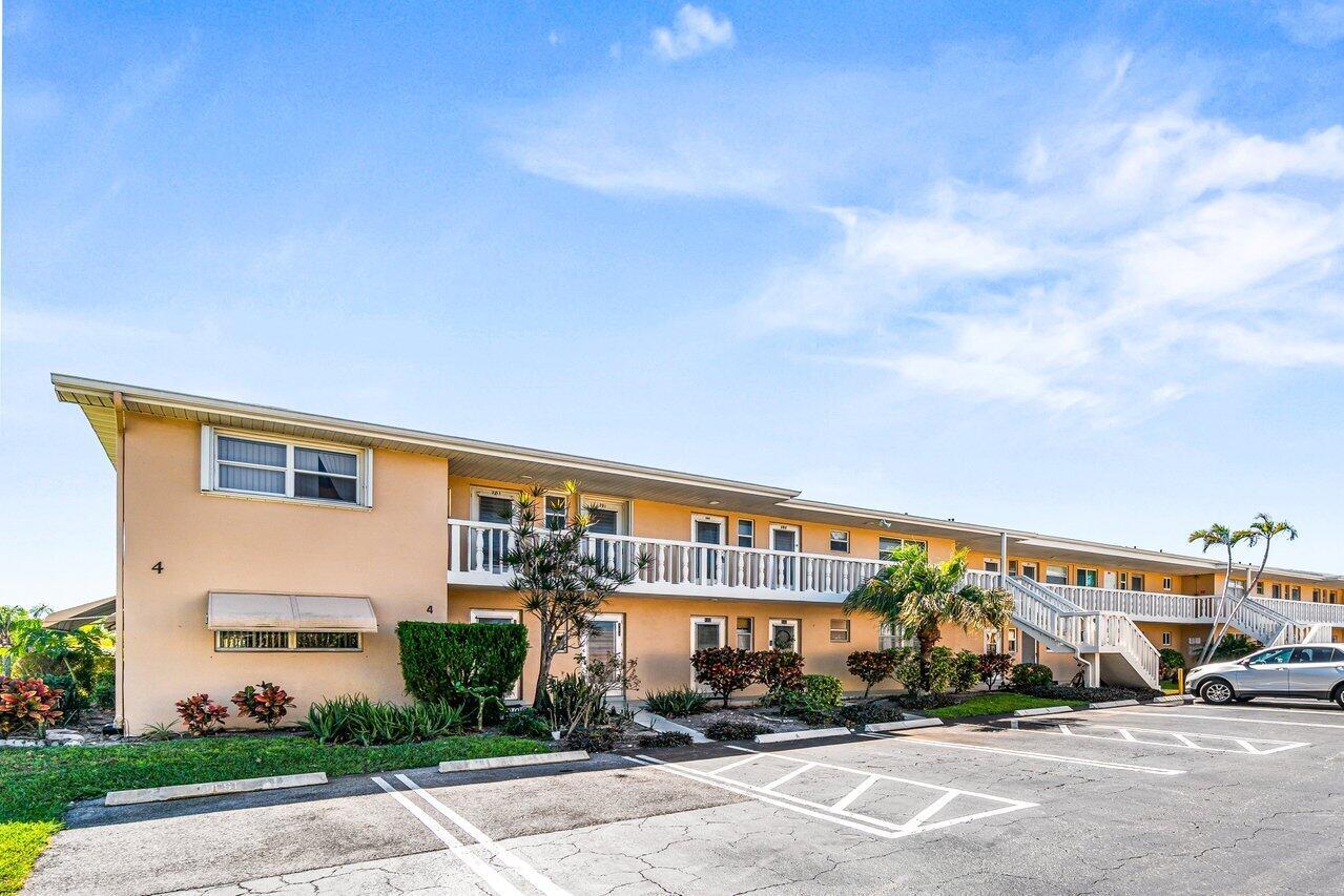 A two-story apartment building with a white balcony and a paved parking lot in front — 2121 NE 1st Court # 202, Boynton Beach FL 33435, BOYNTON BEACH, FL