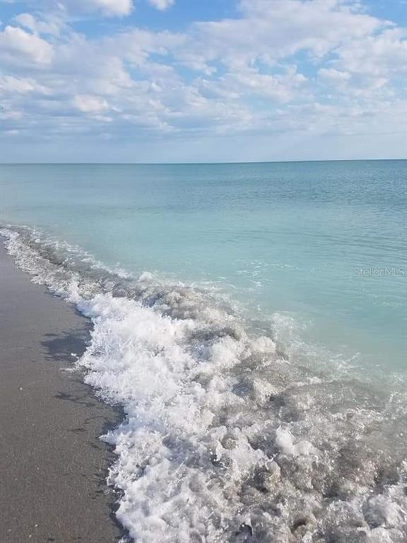 A view of turquoise ocean waves washing onto a sandy beach under a cloudy sky — 14165 DANIELS AVENUE, PORT CHARLOTTE, FL