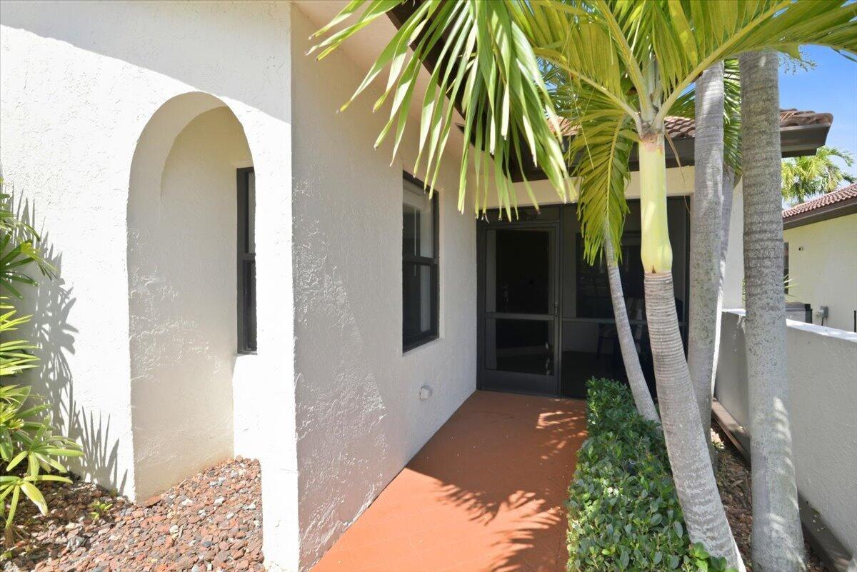 A covered entryway with a terracotta floor leads to a screened door and window — 21583 Villa Nova Drive, Boca Raton FL 33433, BOCA RATON, FL