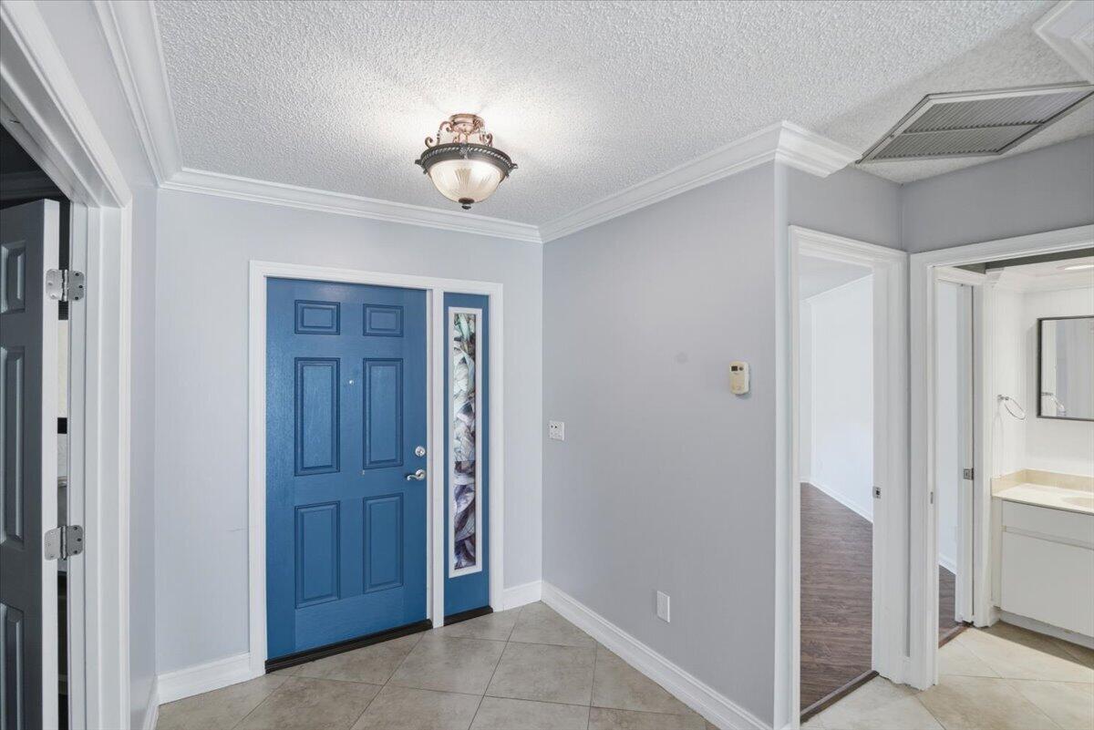 An entryway features a blue front door, light gray walls, and beige tile flooring — 21583 Villa Nova Drive, Boca Raton FL 33433, BOCA RATON, FL