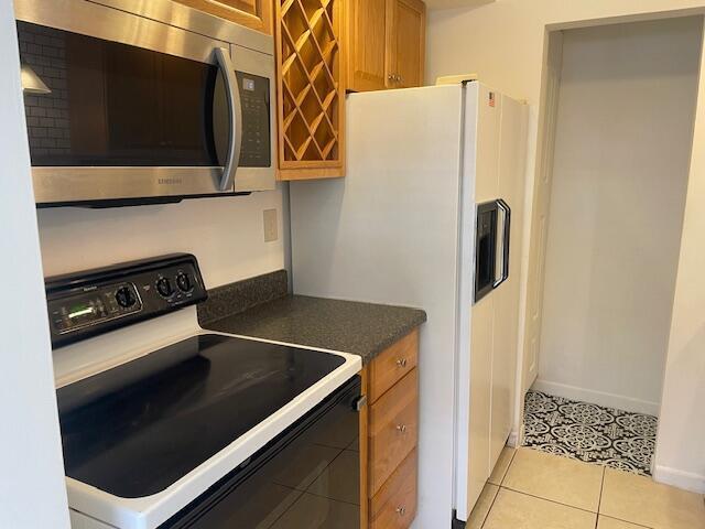 A kitchen features a stainless steel microwave, a black electric stove, and a white refrigerator — 1230 Old Boynton Road # 210, Boynton Beach FL 33426, BOYNTON BEACH, FL