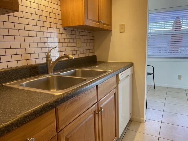 A kitchen features wood cabinets, a double sink, a subway tile backsplash, and a dishwasher — 1230 Old Boynton Road # 210, Boynton Beach FL 33426, BOYNTON BEACH, FL