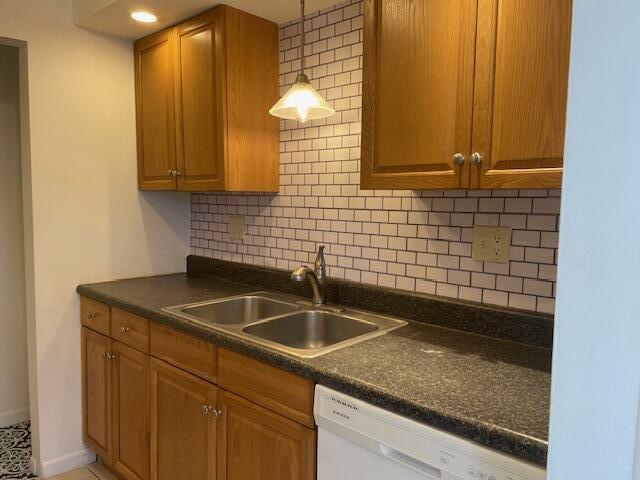 A kitchen features oak cabinets, a dark countertop, a stainless steel sink, and subway tile backsplash — 1230 Old Boynton Road # 210, Boynton Beach FL 33426, BOYNTON BEACH, FL