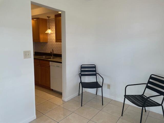 Two black metal chairs sit on a tiled floor in front of a kitchen doorway — 1230 Old Boynton Road # 210, Boynton Beach FL 33426, BOYNTON BEACH, FL