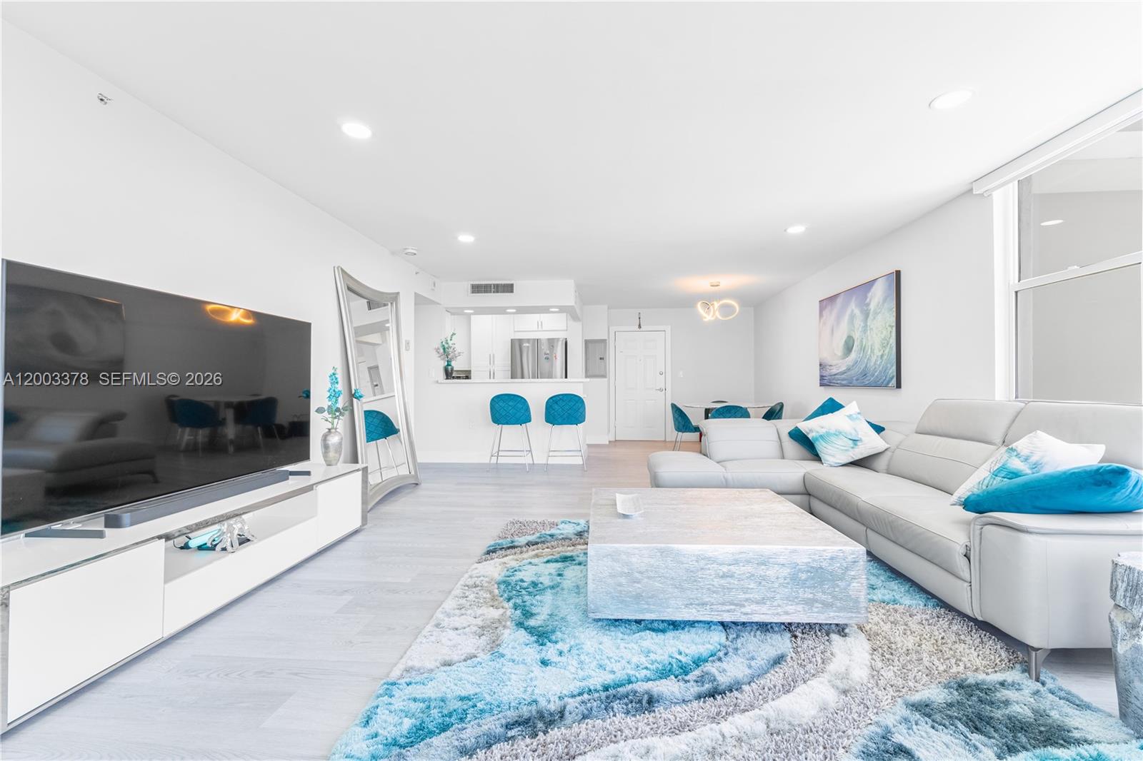 A living room features a grey sectional sofa, a large area rug, and a television — 2501 S Ocean Dr # 536, Hollywood FL 33019, HOLLYWOOD, FL