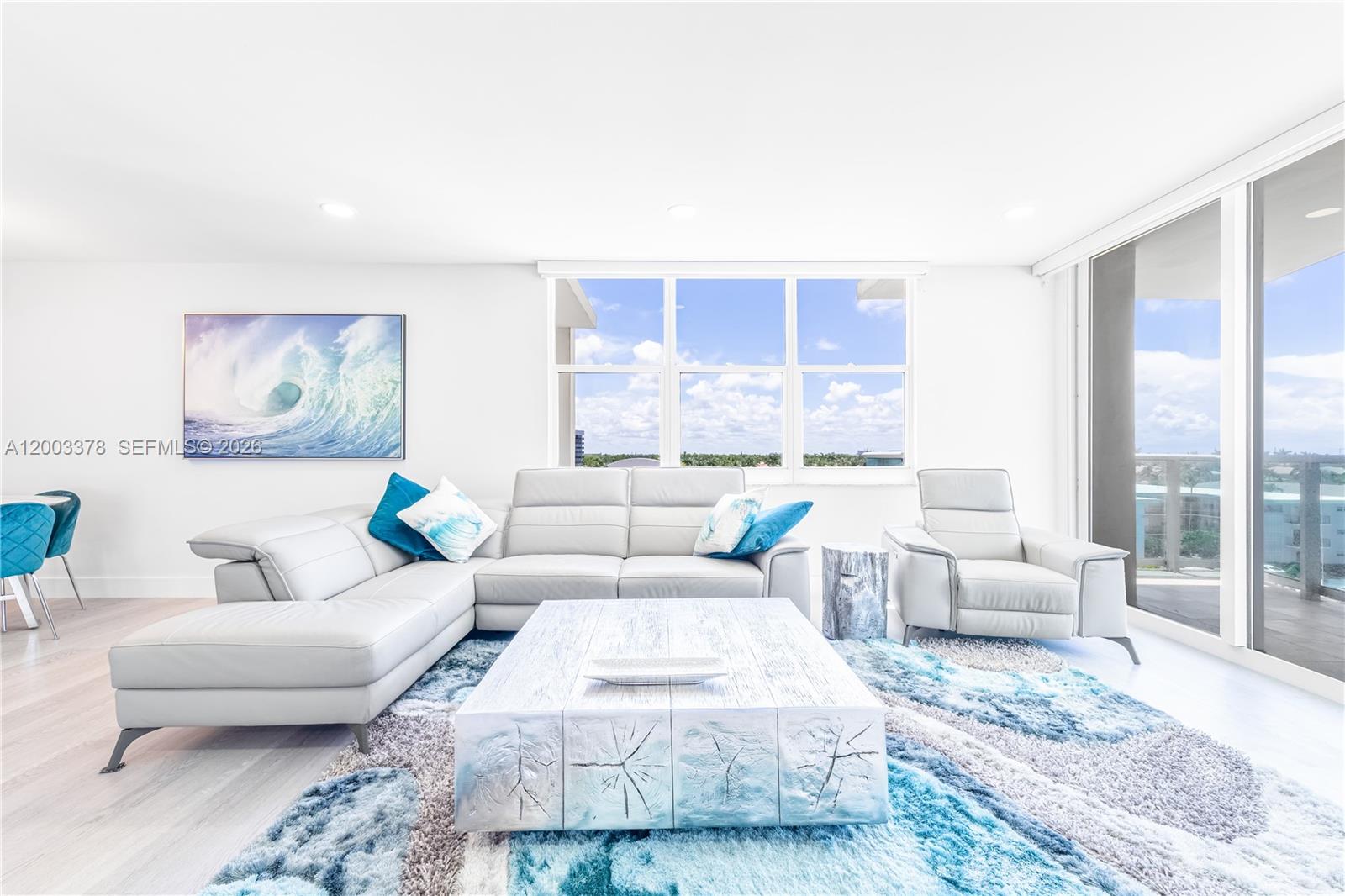 A bright living room features a white sectional sofa, a textured coffee table, and blue accents — 2501 S Ocean Dr # 536, Hollywood FL 33019, HOLLYWOOD, FL