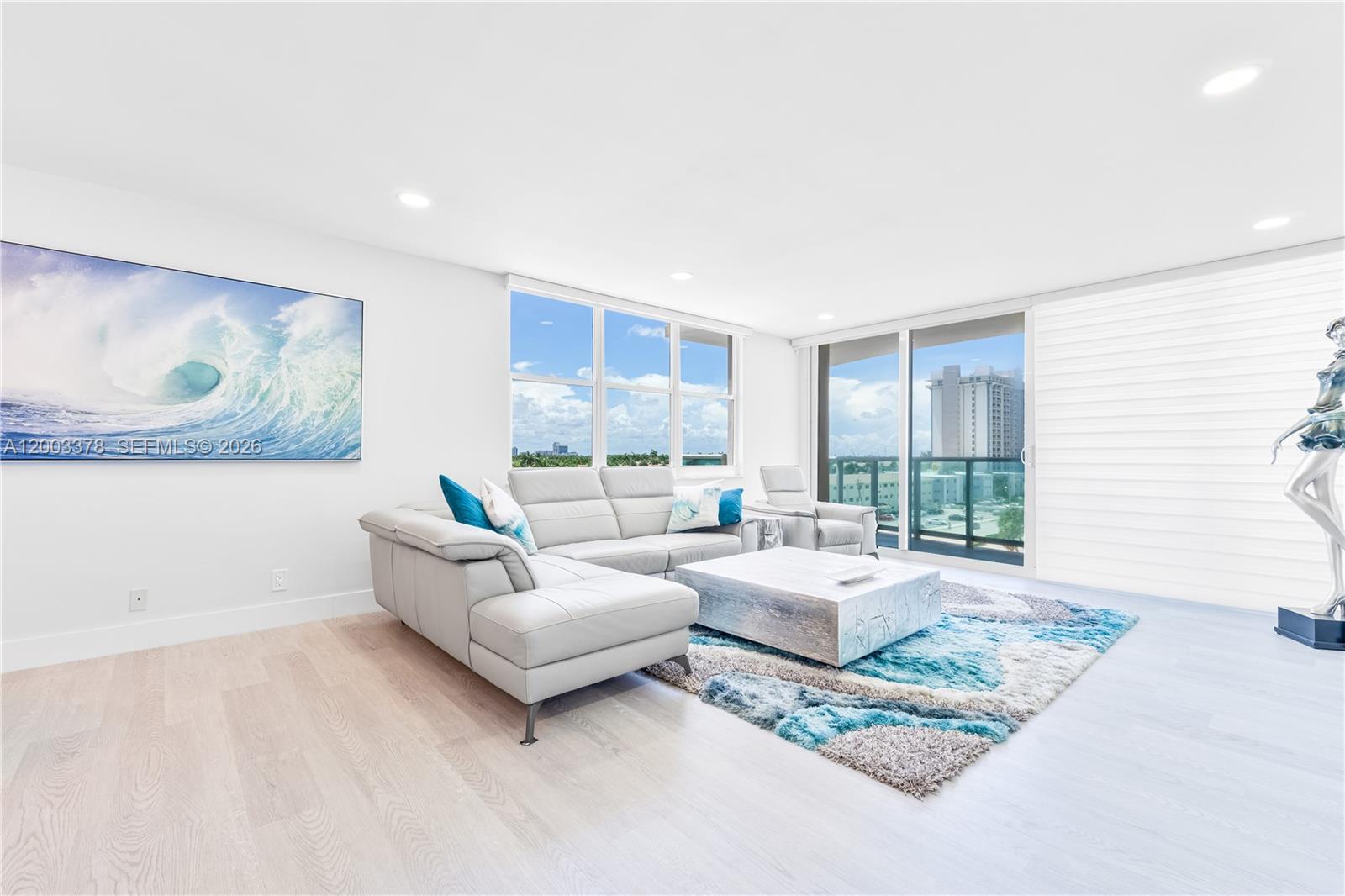 A bright living room features a gray sectional sofa, a textured rug, and a balcony view — 2501 S Ocean Dr # 536, Hollywood FL 33019, HOLLYWOOD, FL