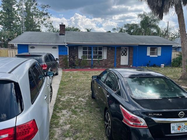 A single-story house with a blue exterior, brick facade, and two cars parked in front — 1717 STATE ROAD 17 N, SEBRING, FL