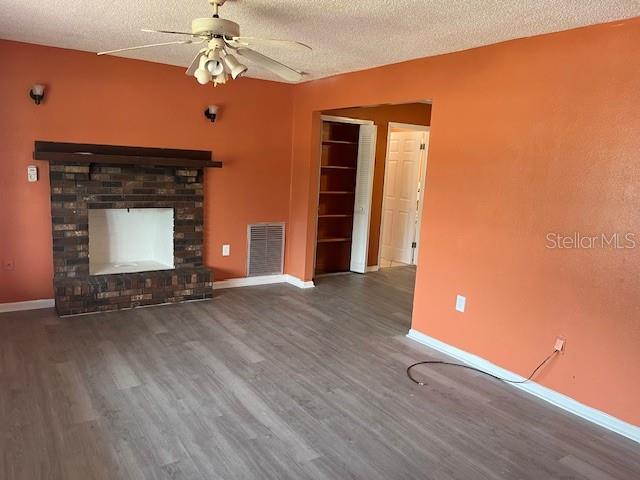 A living room features orange walls, a brick fireplace, a ceiling fan, and wood-look flooring — 1717 STATE ROAD 17 N, SEBRING, FL