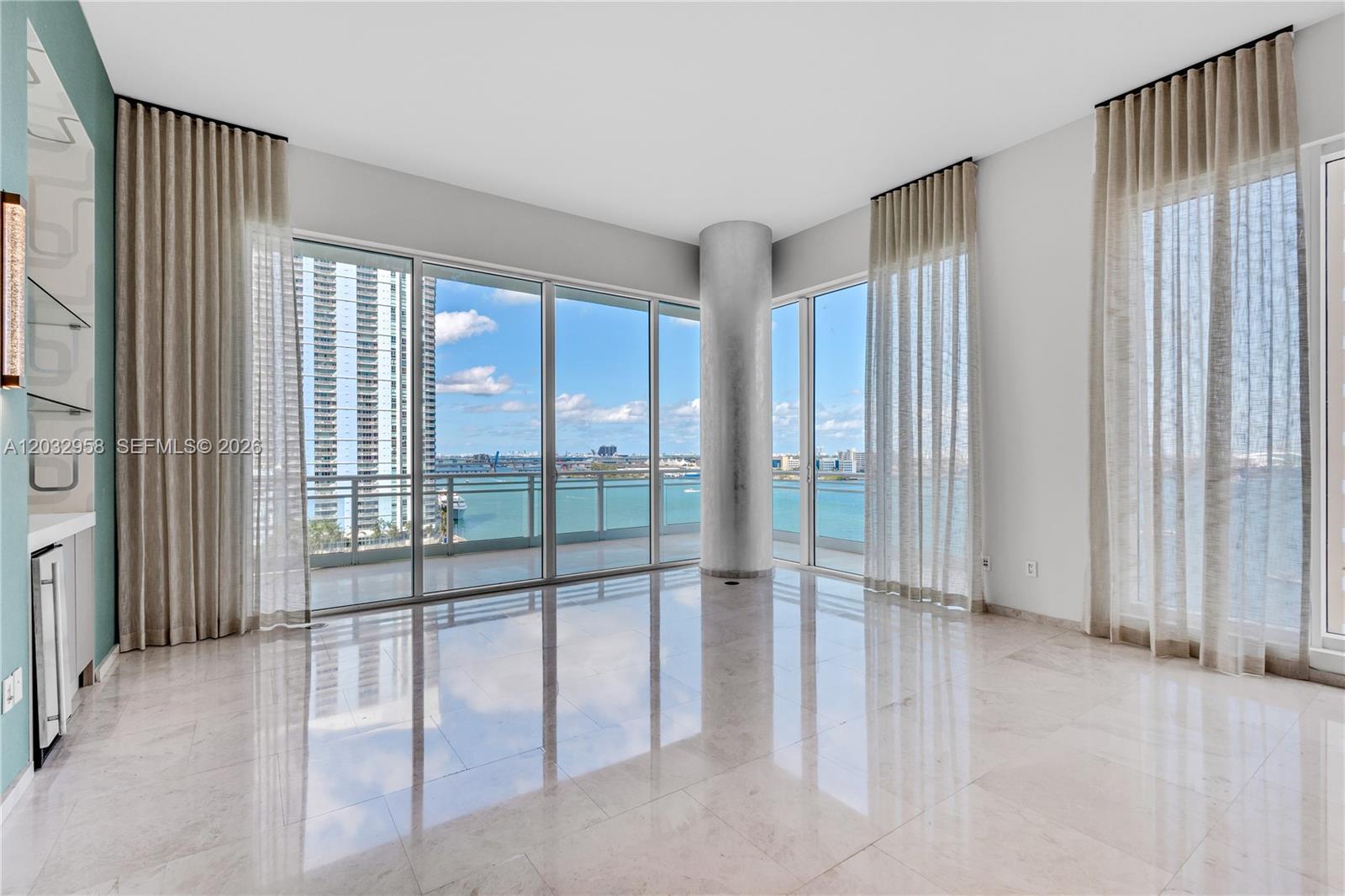 An empty room with marble floors, floor-to-ceiling windows, and a view of the water — 900 Brickell Key Blvd # 1002, Miami FL 33131, MIAMI, FL