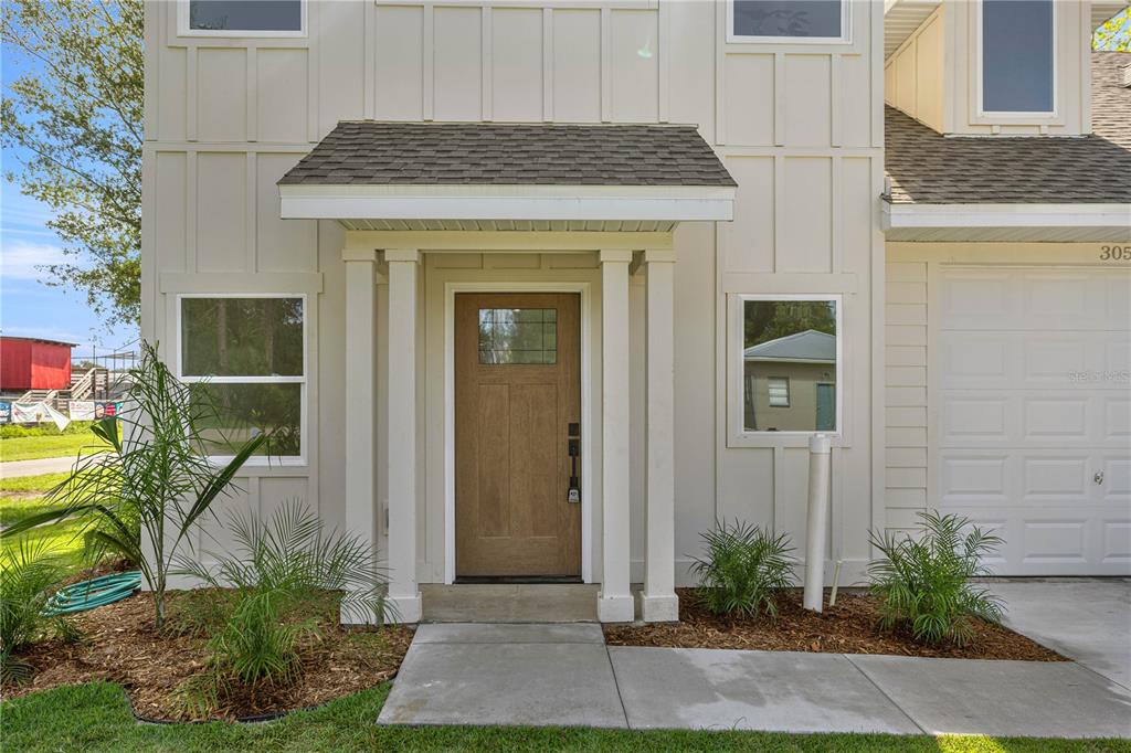 The exterior of a two-story house features light siding, a wood front door, and a garage — 305 SE 5TH TERRACE, WILLISTON, FL
