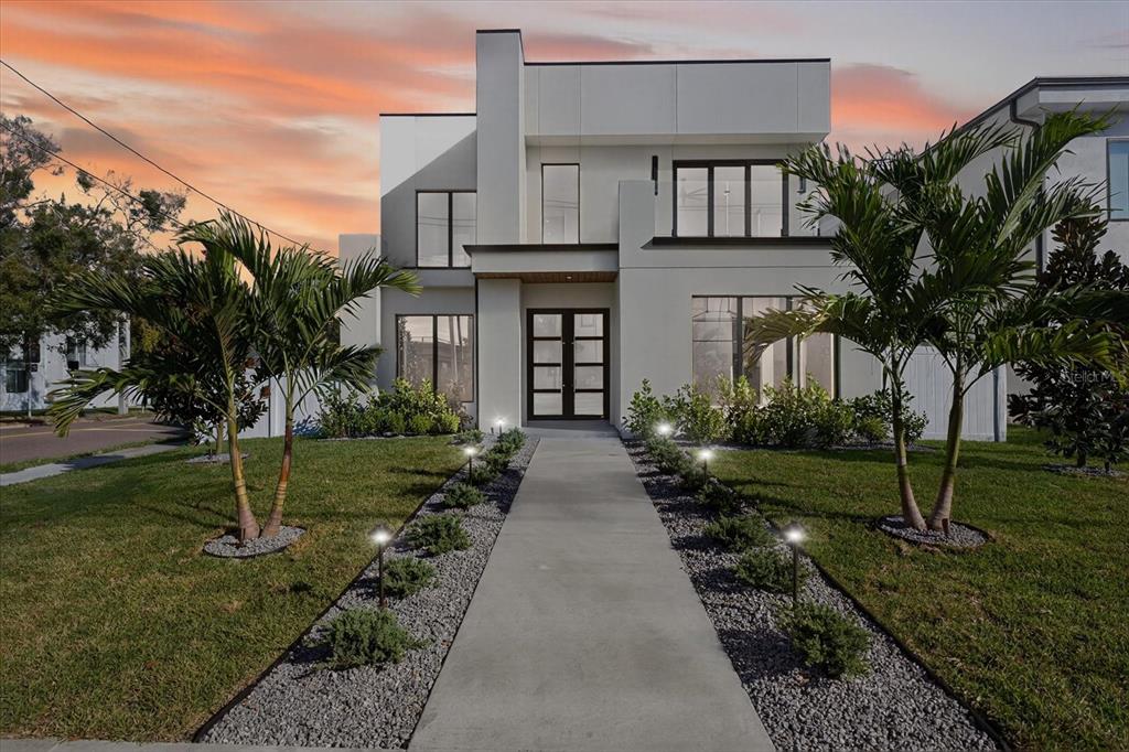 A modern two-story house with a concrete walkway and palm trees in the front yard — 3702 S LYNWOOD AVENUE, TAMPA, FL