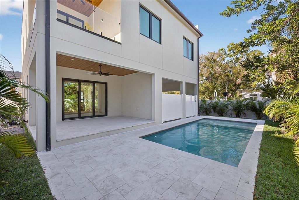 A modern two-story house features a covered patio, a rectangular swimming pool, and stone pavers — 3702 S LYNWOOD AVENUE, TAMPA, FL