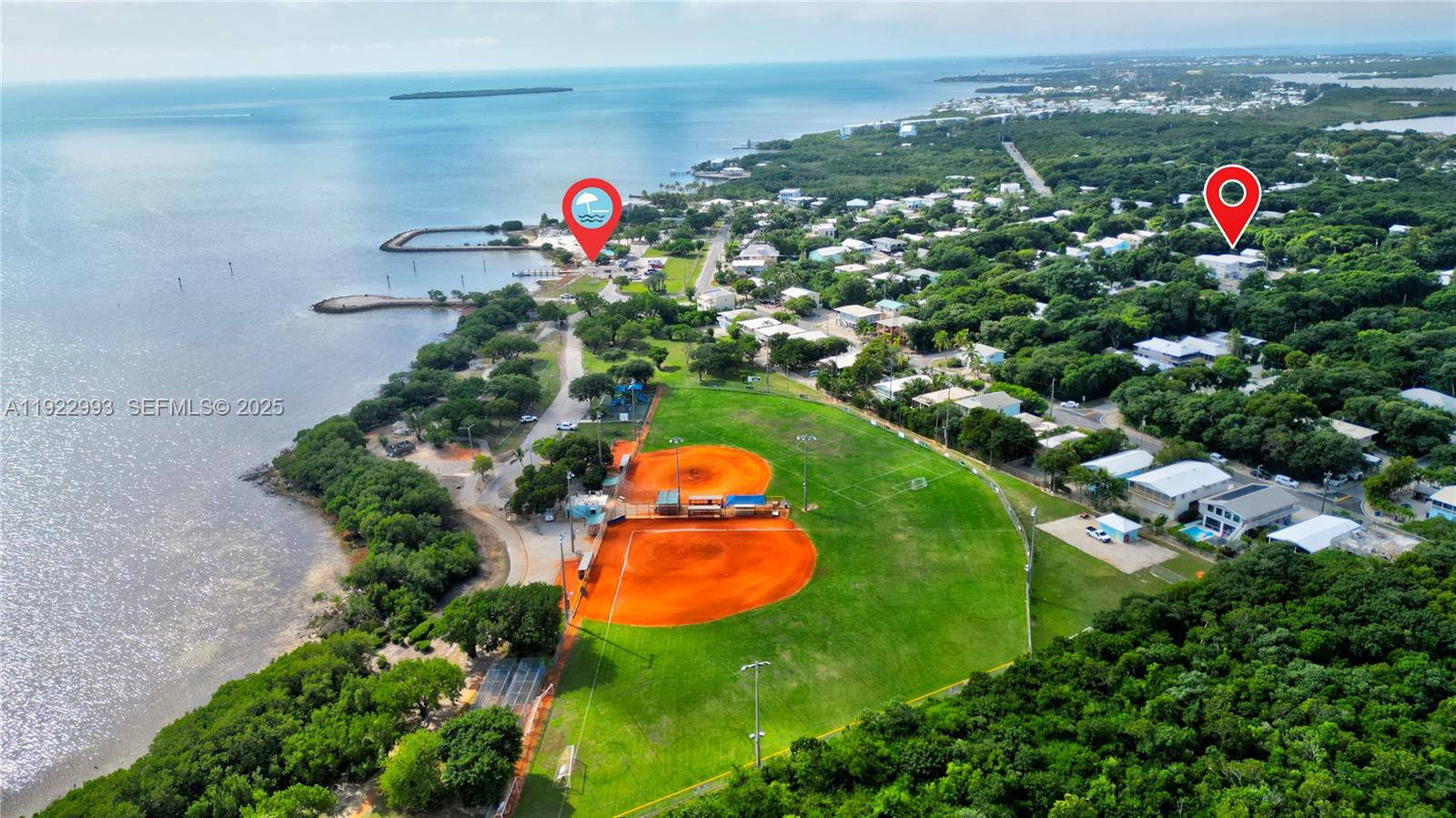 This aerial view shows a coastal park with a baseball field and nearby houses — 137 Pacific Ave, Tavernier FL 33070, TAVERNIER, FL