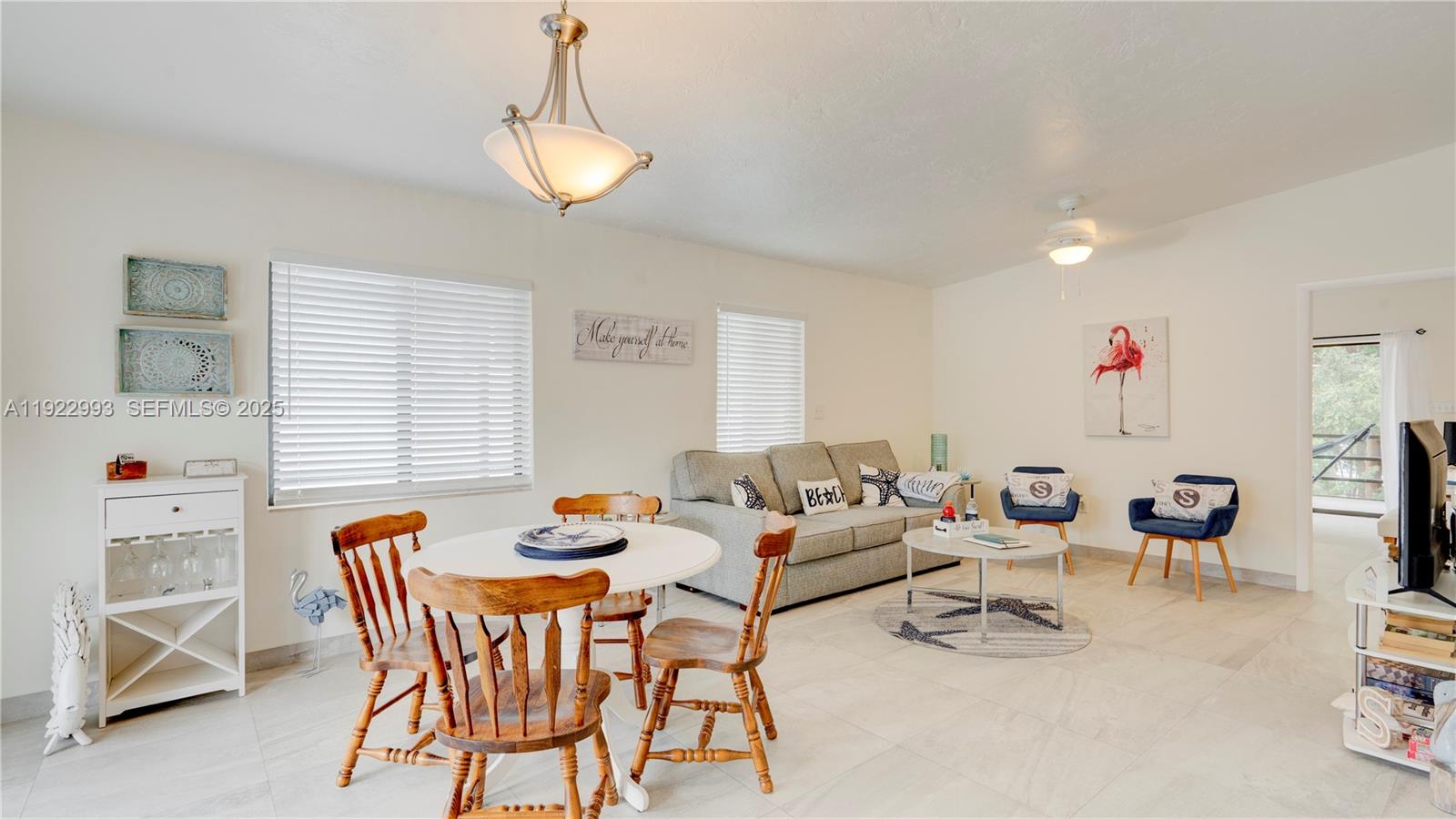 A living and dining area features tile floors, a round table, and a gray sofa — 137 Pacific Ave, Tavernier FL 33070, TAVERNIER, FL