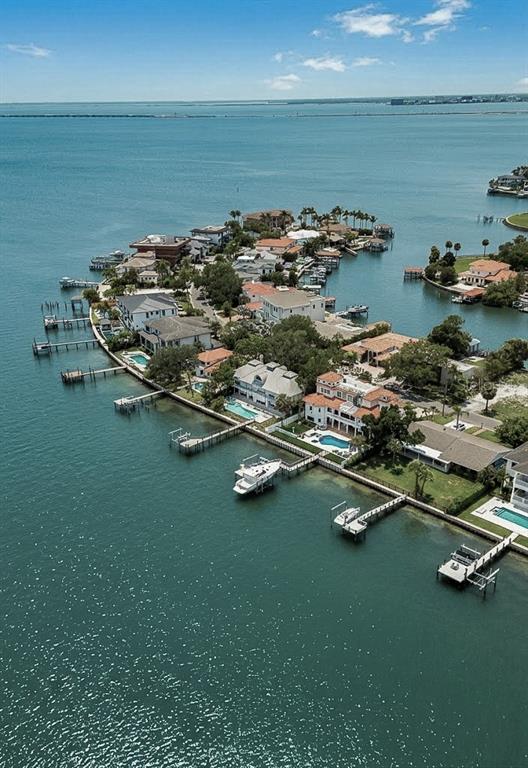 An aerial view shows waterfront homes with private docks and swimming pools along a bay — 5028 W LEONA STREET, TAMPA, FL