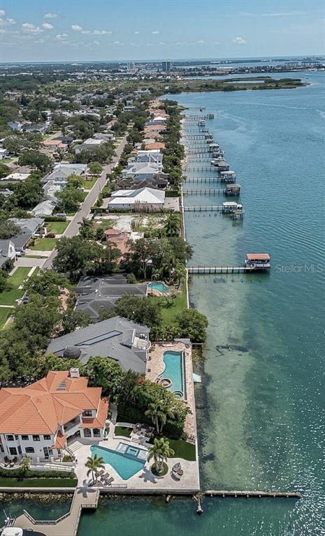An aerial view shows waterfront homes with private docks and swimming pools along a coastline — 5028 W LEONA STREET, TAMPA, FL