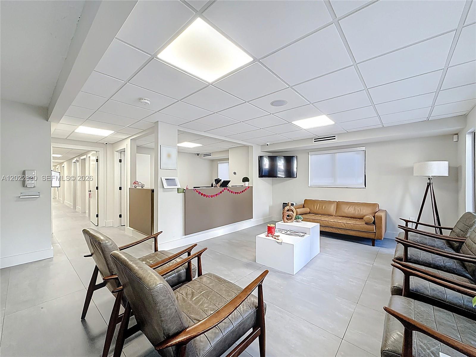 A modern medical office waiting room features leather chairs, a reception desk, and tile flooring — 232 SW 8th St, Miami FL 33130, MIAMI, FL