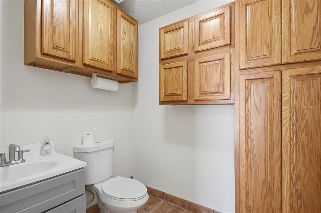 A bathroom features a gray vanity, a white toilet, and light wood cabinetry — 200 WALER WAY UNIT G&H, ST AUGUSTINE, FL