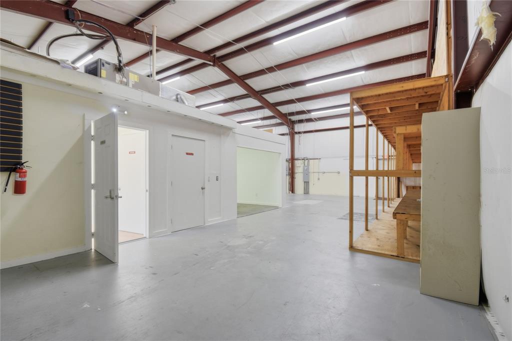 An interior view of a warehouse space with a concrete floor, shelving, and office doors — 200 WALER WAY UNIT G&H, ST AUGUSTINE, FL
